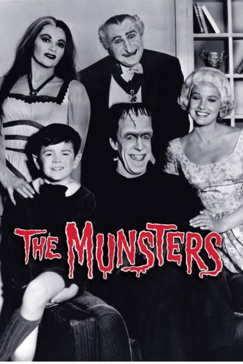 Black-and-white promotional photo of the cast of The Munsters TV show, featuring Lily, Grandpa, Marilyn, Herman, and Eddie Munster smiling together in a family portrait pose, with the show’s red dripping logo at the bottom.